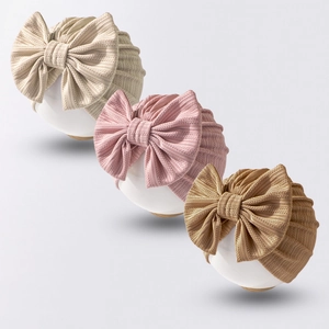Set of 3 waffle knit baby hats with large bows in beige, soft pink, and golden brown