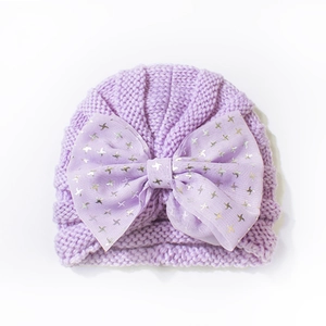 Detail of light purple knit baby turban with mesh bow and silver star foil patterns