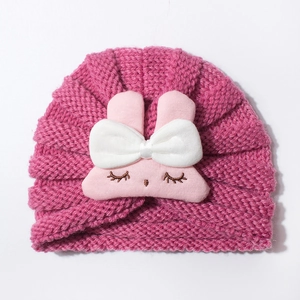Detail of baby knitted hat featuring a cute plush bunny with embroidery and pink bow
