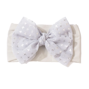 Détail d'un bandeau souple pour bébé avec un nœud en tulle lavande et motifs d'étoiles