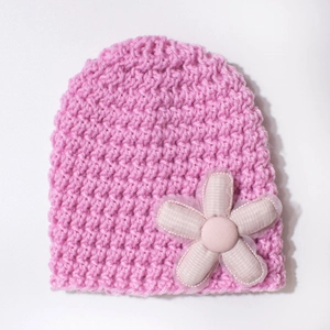 Close-up of pink knit baby hat featuring a textured fabric flower with mesh edge