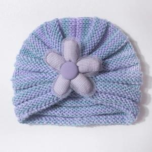 Detailed macro view of the knitted stripe texture and large decorative fabric flower on the hat