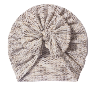 Turbante per neonati beige in maglia a nido d'ape con nodo su sfondo bianco