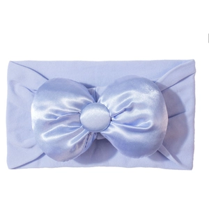 Elastische babyhaarband met een grote lichtblauwe satijnen strik en stoffen knoop