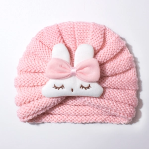 Close-up of pink knitted baby hat featuring cute white bunny decoration with embroidery
