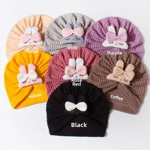 Detail view of colorful ribbed knit baby beanies with cute 3D bunny bow decorations