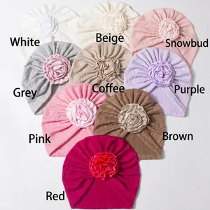 Close-up of baby turban hats with large 3D flowers in multiple soft colors