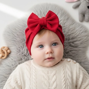 Close-up of baby girl wearing a bright red waffle knit headband with a large bow detail