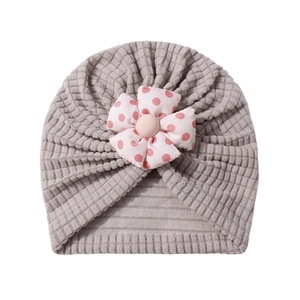Gray waffle knit baby turban hat with a cute pink red polka dot flower decoration