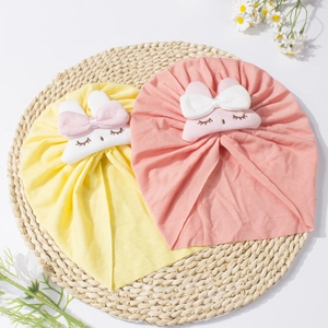 Dettaglio di cappellini in maglia per neonati con graziosi coniglietti in giallo e rosa