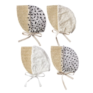 Detail of four baby sun hats with lace embroidery and straw patchwork design