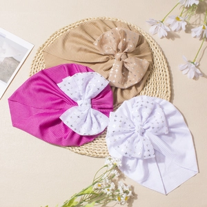 Detailed knit texture of baby turbans with large bows and silver star patterns