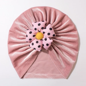 Pink velvet baby turban hat featuring a large polka dot flower and soft thermal fabric