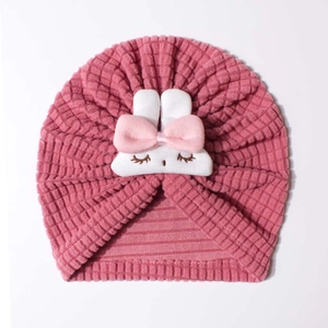 Detail of waffle knit fabric and cute plush rabbit on the pink infant beanie