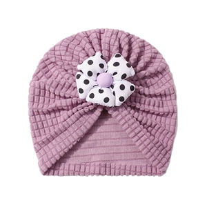 Close-up of purple knit baby turban with a white and black polka dot fabric flower