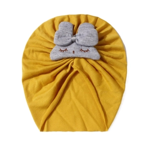 Dettaglio del cappello a turbante giallo per neonati con graziose orecchie di coniglio