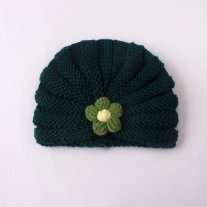 Bonnet en tricot vert foncé pour bébé avec une jolie fleur jaune cousue sur le devant