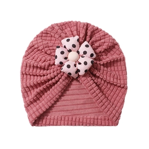 Detail of pink waffle knit baby turban hat with black polka dot flower decoration