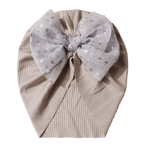 Detailed close-up of ribbed cotton baby turban with a sparkling mesh bow and star prints