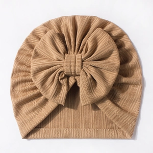 Detailed close-up of soft waffle texture and decorative bow on the baby beanie