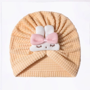 Close-up of baby waffle knit hat with cute white rabbit and pink bow decoration