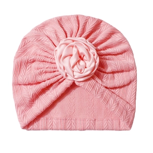 Pink cable knit baby turban hat with a large satin rose flower decoration for infants