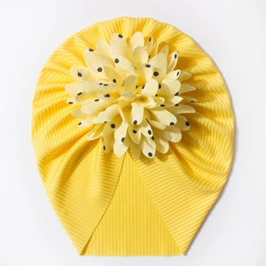 Détail d'un turban bébé jaune côtelé avec fleur 3D ornée de pois noirs contrastants