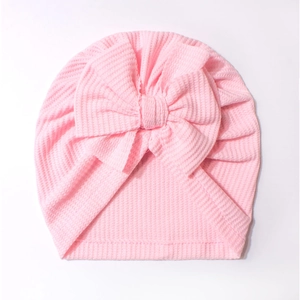 Bonnet turban rose pour bébé en maille gaufrée avec un grand nœud décoratif