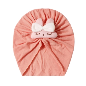 Dettaglio del turbante neonato rosa corallo con morbido coniglietto e ricami delicati