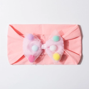 Detail of pink baby headband with large mesh bow filled with colorful plush pom-poms