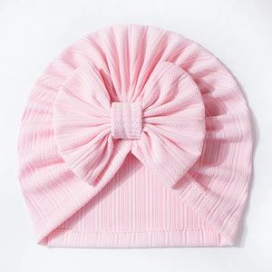 Detailed close-up of pink waffle texture baby hat featuring a large cute soft bow