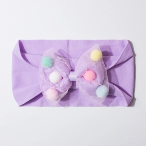 Detailed view of purple baby headband featuring a mesh bow filled with colorful pom-poms