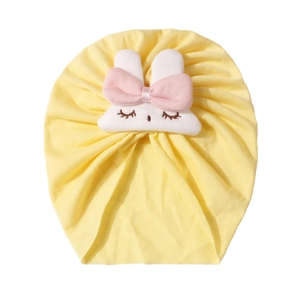 Dettaglio del cappellino neonato con decoro a coniglio bianco e fiocco rosa giallo