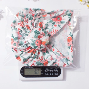 Détail du bonnet donut pour bébé pesant 30g avec motif floral multicolore