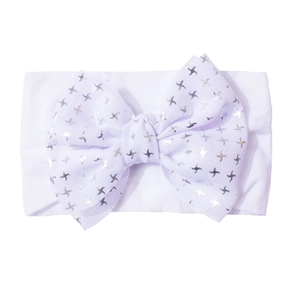 Détail d'un bandeau blanc en nylon pour bébé avec un grand nœud à motifs d'étoiles argent
