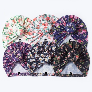 Détails de bonnets donut pour bébés avec motifs floraux variés et nœud décoratif haut