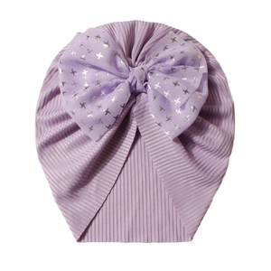 Detailed view of lavender ribbed baby hat with a large bow and silver star patterns