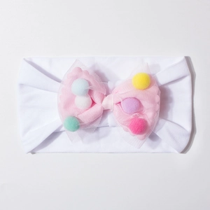 Detail view of baby elastic headband with white soft fabric and pink mesh bow decoration