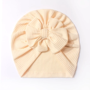 Bonnet turban bébé en maille gaufre crème avec un grand nœud décoratif pour nourrisson