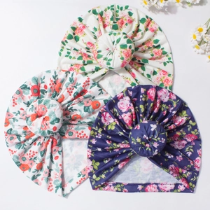 Vue détaillée de trois bonnets donuts pour bébé aux motifs floraux et tissus doux
