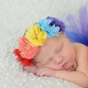 Accessoire photo pour bébé avec bandeau fleurs colorées sur nourrisson endormi