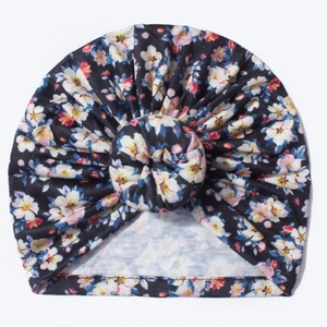 Détail du bonnet turban pour bébé avec imprimé floral coloré et nœud de type donut