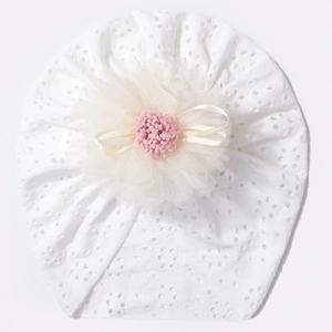 Detail of white hollow breathable infant hat with mesh flower and pink plush center