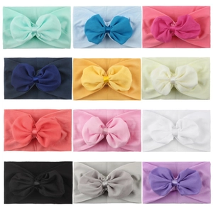 Vue à plat de 12 bandeaux en nylon colorés avec nœuds en mousseline pour bébés filles