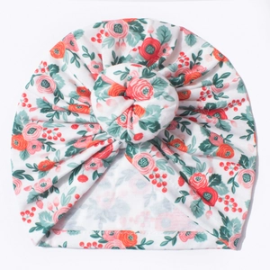 Détail du bonnet turban pour bébé avec imprimé floral rose et nœud beignet en coton