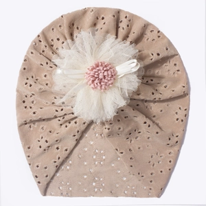 Detail of baby turban hat with hollow embroidery and large 3D mesh floral decoration