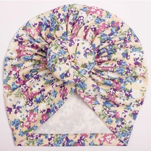 Close-up detail of infant donut turban hat featuring floral print on ribbed cotton fabric