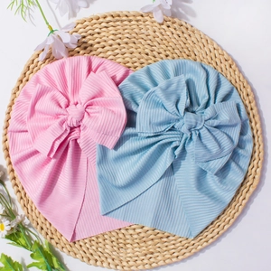 Detail of pink and blue baby turbans with large bows on soft ribbed knit fabric