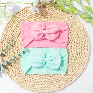 Détail de bandeaux bébé en nylon souple avec grands nœuds en mousseline rose et menthe