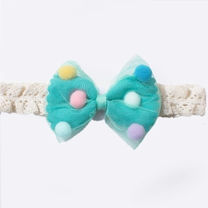 Detail of baby lace headband with mesh bow and colorful pom poms on white background